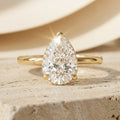 AETERNA ROSÉE pear cut moissanite engagement ring, 3ct, hidden halo, yellow gold — front view