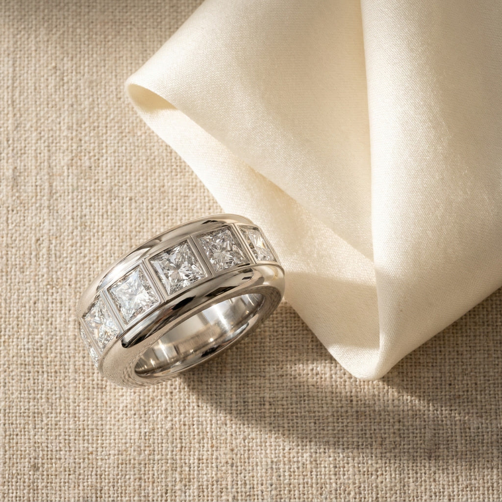 BASTION princess cut lab grown diamond wide band in white gold, photographed on oatmeal linen with folded ivory silk