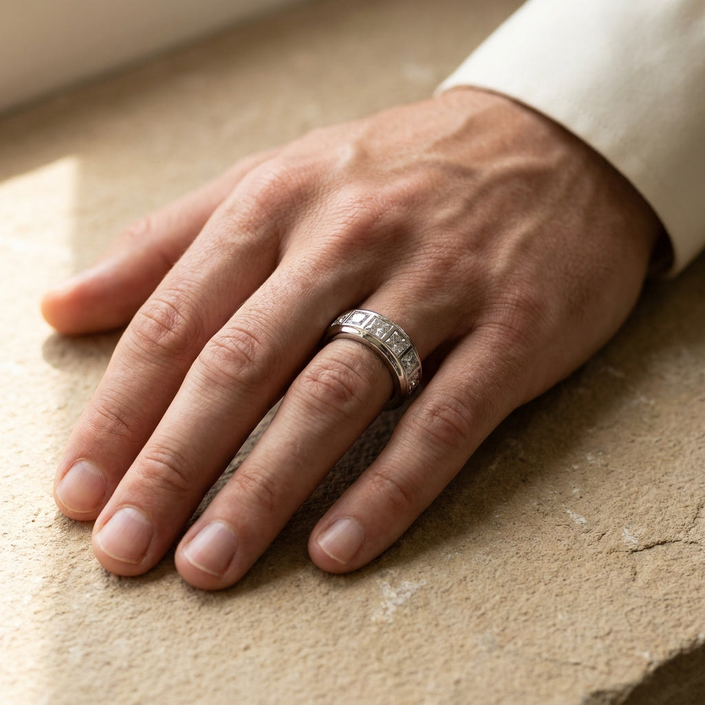 BASTION wide princess cut diamond band worn on a man's hand resting on a limestone surface