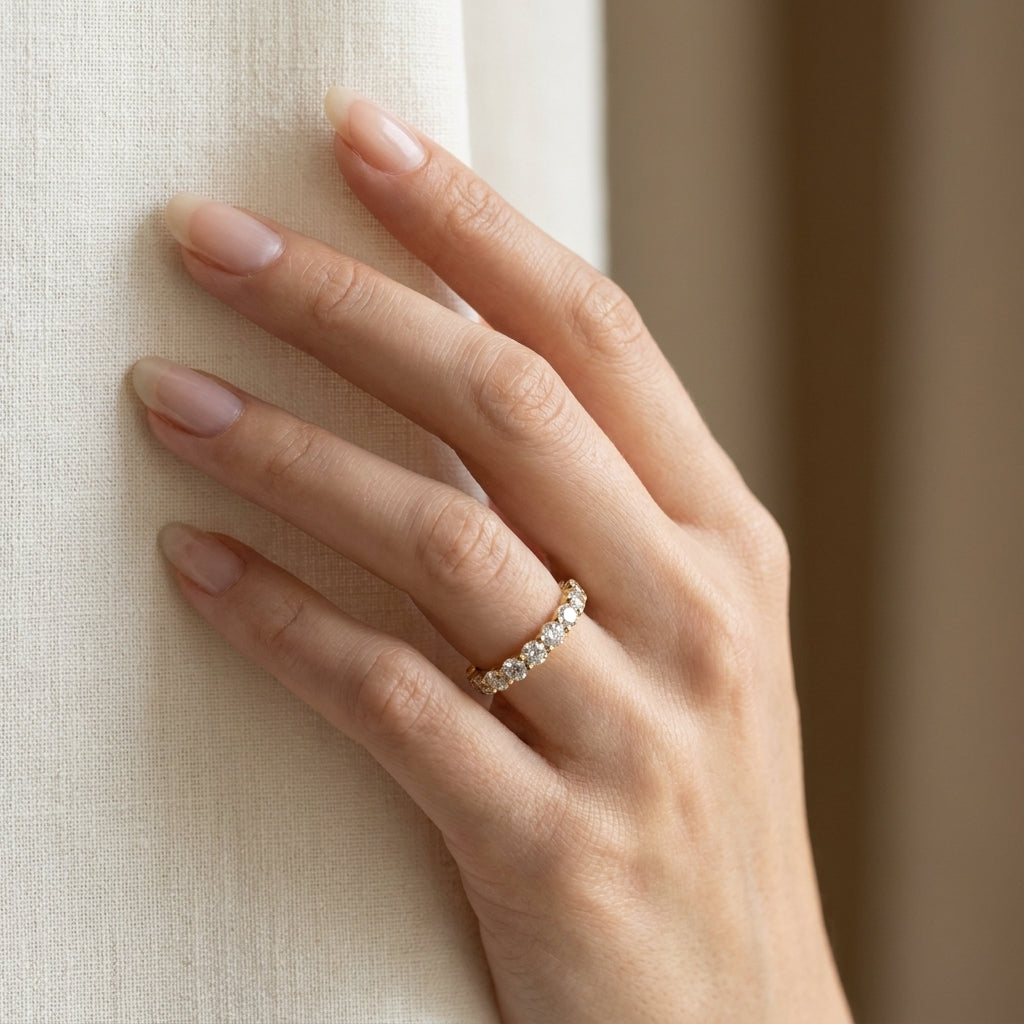 LUMINA GRANDEUR round moissanite eternity band — worn on hand against linen