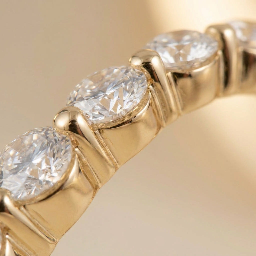 Macro detail of the shared-prong 2.5 mm round moissanite stones on the LUMINA SCINTILLE band