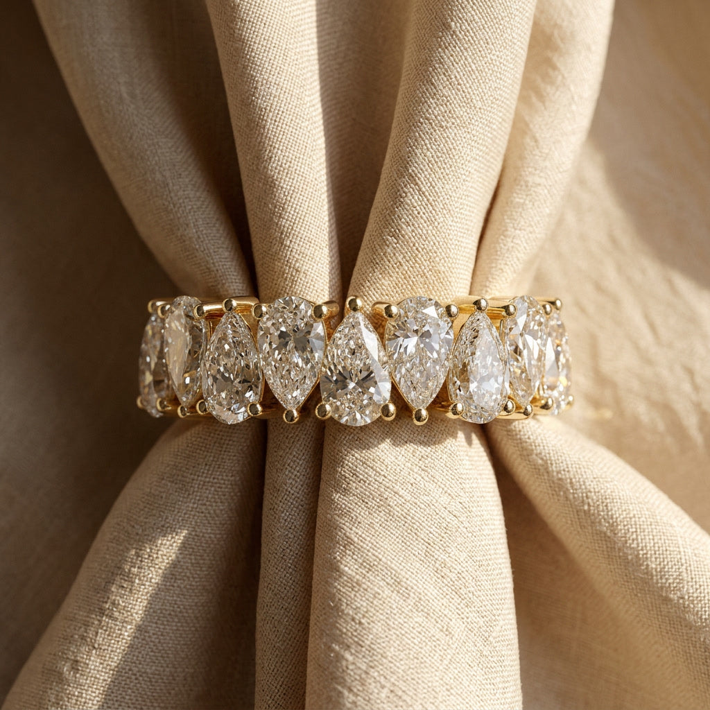 Pear-cut moissanite half-eternity band, editorial linen flat lay
